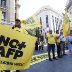 Personas sosteniendo banderas durante una manifestación en contra de las Administradoras de Fondos de Pensiones (AFP), en Santiago (Chile).