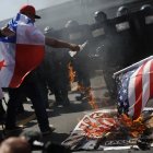 Personas queman una bandera de Estados Unidos durante una protesta por la visita del Secretario de Estado de Estados Unidos, Marco Rubio.