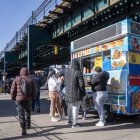 Personas consumen alimentos en un puesto de comida callejera este miércoles, en Queens Nueva York (Estados Unidos).