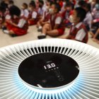 Bangkok. Niños de jardín de infantes se sientan dentro de una habitación equipada con un purificador de aire.