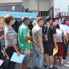 Migrantes hacen fila frente a las instalaciones de la Comisión Mexicana de Ayuda a Refugiados (Comar) este viernes 7 de febrero, en Tapachula (México).