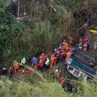 Integrantes de organismos de socorro trabajan en la zona donde ocurrió el accidente de un autobús, que cayó en un río de aguas residuales este 10 de febrero de 2025 al norte de la Ciudad de Guatemala.