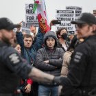 Manifestantes observan a los agentes de la policía después de que los agentes realizaron uno de los dos arrestos durante una marcha contra el ICE en Seattle, el 8 de febrero de 2025.