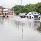 Los vehículos sufren dificultades al transitar por calles anegadas.