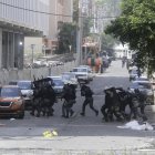 Policías antidisturbios enfrentan a integrantes de grupos sindicales durante protestas este miércoles en la cinta costera en Ciudad de Panamá (Panamá).