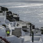 A municipal employee walks in the village of Oia on the Greek island of Santorini while the authorities restricted  access to the tourists in some areas as a precaution due to recent seismic activity on February 5, 2025. Some 7,000 people have left the island, known for its spectacular cliffside views and dormant volcano, which has been hit by hundreds of tremors since January 24, 2025, officials said. (Photo by STRINGER / AFP)