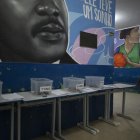 Una estudiante camina hacia su salón de clases después de dejar su teléfono celular en una caja al comienzo del día escolar en la escuela pública Reverend Martin Luther King en Río de Janeiro.