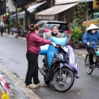 La gente carga bolsas de arroz en una motocicleta en una calle de Hanoi, Vietnam, el 18 de febrero de 2025.