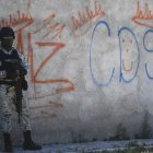 Un soldado hace guardia junto a algunos grafitis del narcotraficante Mayo Zambada (MZ) y el grupo criminal Cártel de Sinaloa, municipio de Jerez de García Salinas, estado de Zacatecas, México