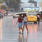 La lluvia se sintió en algunas partes de la ciudad. Se veía a personas resguardándose de las precipitaciones