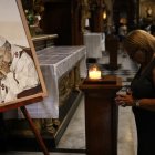 Una mujer reza junto a un cuadro que representa al Papa Francisco en la Basílica de San José de Flores en Buenos Aires, este domingo 23 de febrero de 2025.