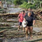 Ana Segovia y otros vecinos caminan entre la palizada de lo que era la vía principal de El Mate, en la parroquia Calderón, Portoviejo en Manabí.