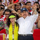 El presidente Daniel Ortega y su esposa, Rosario Murillo, hacen el signo V durante la conmemoración de aniversario de la Revolución Sandinista en la plaza La Fe en Managua.