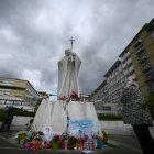 Una mujer reza ante la estatua de Juan Pablo II afuera del hospital Gemelli, donde el Papa Francisco está hospitalizado con neumonía, en Roma, el 28 de febrero de 2025.