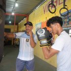 El entrenador y excampeón de boxeo Pablo Álvarez (c), comparte sus enseñanzas todas las tardes con jóvenes en el suburbio de Guayaquil.