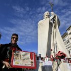Rome (Italy), 02/03/2025.- Faithful with a sign stand in front of the statue of Pope John Paul II at the entrance to the Gemelli Hospital, where Pope Francis is hospitalized, in Rome, Italy, 02 March 2025. Pope Francis was admitted to the Agostino Gemelli Hospital in Rome on February 14 due to a respiratory tract infection. (Papa, Italia, Roma) EFE/EPA/RICCARDO ANTIMIANI