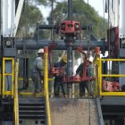 Cuatro personas realizan trabajo en uno de los pozos de petróleo de Ecuador, como en el campo Sacha.
