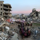 La gente se reúne entre los escombros de los edificios destruidos para celebrar una reunión masiva para romper el ayuno del iftar en el segundo día del mes sagrado musulmán del Ramadán.