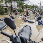 Los rescatistas caminan a través de las aguas de la inundación cerca de motocicletas sumergidas en una zona residencial de Bekasi, Java Occidental, Indonesia, el 4 de marzo de 2025.