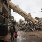Un hombre palestino junto a un niño camina cerca de un minarete caído de una mezquita destruida el mes sagrado del Ramadán, en el campo de refugiados de Nuseirat, en la Franja de Gaza, el 7 de marzo de 2025.