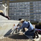 Un artista dibuja ante la escultura del papa Juan Pablo II, a las puertas del Hospital Gemelli donde permanece ingresado el papa.