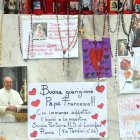 Velas, rosarios y mensajes de apoyo al papa Francisco se exhiben en la estatua del papa Juan Pablo II junto al Hospital Universitario Gemelli.