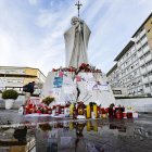 Un feligrés católico reza junto a la estatua de Juan Pablo II, frente al hospital Gemelli de Roma.