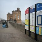 Los peatones caminan junto a las torretas de la entrada del antiguo muelle de Withernsea, en la costa este de Inglaterra, el 10 de marzo de 2025.