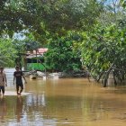 Inundación. Dos jóvenes caminan en un área anegada de Los Ríos.