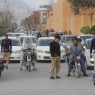 Funcionarios de seguridad inspeccionan vehículos en un puesto de control después de que se intensificara la seguridad tras un presunto ataque militante a un tren de pasajeros