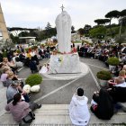 Un grupo de peregrinos rusos se reúne junto a la estatua de Juan Pablo II en la entrada del Hospital Gemelli, donde está hospitalizado el Papa Francisco, en Roma, Italia, el 11 de marzo de 2025.