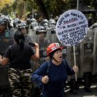 Personas se manifiestan durante una protesta frente a miembros de la Policía Nacional Bolivariana (PNB) que custodian los accesos a la Universidad Central de Venezuela (UCV), en Caracas (Venezuela).