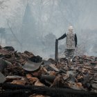 Un auxiliar caminando sobre los escombros causados tras la expansión de los incendios forestales surcoreanos.