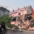 Gente pasa al frente de un edificio colapsado tras un terremoto ocurrido en Birmania el 28 de marzo de 2025.