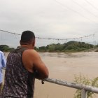 Pobladores de la parroquia Magro observan con asombro el puente Gonzalo Icaza Cornejo, colapsado y sumergido en las aguas del río Daule.