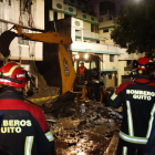 Los bomberos y maquinaria pesada trabajan para retirar los escombros tras el deslizamiento en Guápulo, que afectó varias viviendas.