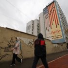 Transeúntes pasan por calles iraníes con el trasfondo de propaganda antiestadounidense