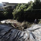 Los trabajadores municipales cubrieron parte del talud que rodea a una de las quebradas que se desbordaron por las fuertes lluvias en Quito.