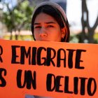 Una mujer sostiene un cartel durante una manifestación en apoyo a la migración.