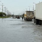 Inundación. En la vía Babahoyo-Jujan, los vehículos intentaron pasar con precaución cuando el agua empezó a bajar; y aún así fue complejo hacerlo.