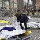 Un policía inspecciona los cuerpos de las víctimas del ataque ruso con misiles balísticos contra el centro de la ciudad nororiental de Sumi, Ucrania, el 13 de abril de 2025.