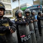 Integrantes de la Policía custodian durante una manifestación de transportistas en Lima (Perú).
