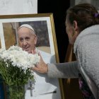 Una mujer rinde homenaje ante un retrato del difunto Papa Francisco frente a la Parroquia de Caacupé en Buenos Aires el 21 de abril de 2025.