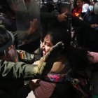 Integrantes de la Policía Boliviana y maestros al enfrentarse este lunes, 21 de abril, durante una manifestación frente al Ministerio de Educación, en La Paz (Bolivia).