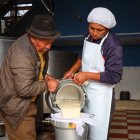 El proceso de ordeñar a la vaca y luego transportar la leche para su comercialización.