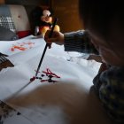 Esta foto tomada el 8 de abril de 2025 muestra a la artista "Pulgarcita" (derecha), de 21 meses, usando un pincel para pintar en la casa de la familia en Tokio.