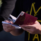 Un migrante sostiene su pasaporte para ser inspeccionado por la Patrulla Fronteriza de EE. UU.