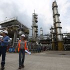 Dos trabajadores caminan en el interior de la Refinería de Esmeraldas.