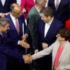 El líder de la Unión Socialcristiana (CDU), Friedrich Merz (al fondo, izq.), estrecha la mano del copresidente del SPD, Lars Klingbeil, tras firmar un acuerdo de coalición para formar el nuevo gobierno.