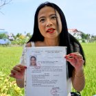 Odile Dussart, quien fue evacuada antes de que termine la guerra de Vietnam hace 50 años, muestra su certificado de nacionalidad vietnamita en su casa recién alquilada en Hoi An.